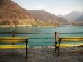 Yellow wooden bench along the turquoise blue lake in Slovenia, Europe.At the background of the Alps and the hills. Unspoiled natur