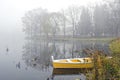 Yellow wooden boat on autumn lake and morning mist Royalty Free Stock Photo