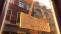 Yellow wooden Closed sign at small street cafe's glass door