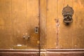 Yellow wooden door with antique door knocker Royalty Free Stock Photo
