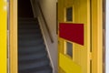 Yellow wooden door into steep staircase in a commercial building