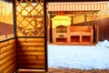 Yellow wooden gazebo with brick grill or barbecue in the yard on a Sunny winter day