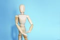 Yellow wooden maniken is dancing and doing poses on blue background Royalty Free Stock Photo