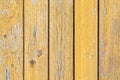 Yellow wooden peeling wall. Old painted vertical boards. Textured Background. Royalty Free Stock Photo