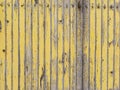Yellow wooden plank wall with peeling paint