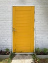 Yellow wooden vintage door on white old brick wall Royalty Free Stock Photo