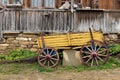 Yellow wooden waggon in front of old house in Jeravna village Royalty Free Stock Photo