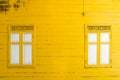 Yellow wooden wall with white window Royalty Free Stock Photo