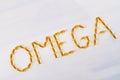 Yellow word omega made of pills.