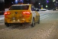 Yellow Yandex Taxi Volkswagen Polo car moving on night snow covered road in Tula, Russia Royalty Free Stock Photo