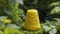 Yellow yarn cone in nature surrounded by green leaves