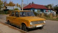 Yellow Zhiguli car in a Russian Village