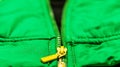 Yellow zipper on green jacket close up concept for advertisement