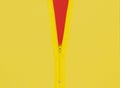 Yellow zipper unzipped half way showing red color under a yellow background