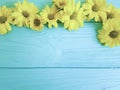 Yellows flowers decoration frame on a blue wooden background Royalty Free Stock Photo