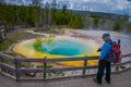 YELLOWSTONE, MONTANA, USA MAY 24, 2018: Outdoor view of tourists walking and taking picture of beautiful and colorful