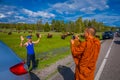 YELLOWSTONE, MONTANA, USA MAY 24, 2018: Unidentified monk taking pictures with a camera to a tourist, with a herd of