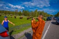 YELLOWSTONE, MONTANA, USA MAY 24, 2018: Unidentified monk taking pictures with a camera to a tourist, with a herd of