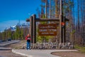 YELLOWSTONE, MONTANA, USA MAY 24, 2018: Unidentified woman waiting in an informative sign of Grand Teton in Yellowstone