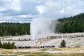 People on boardwalk around the Beehive Geyser watching it erupting