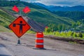 YELLOWSTONE NATIONAL PARK, WYOMING, USA - JUNE 07, 2018: Informative sign with red flags and red cone with equipment