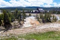 Yellowstone, Wyoming, USA, May 25, 2021, Tourists at the Firehole river and the Old Faithful Inn at the Upper Gyser Basin Royalty Free Stock Photo