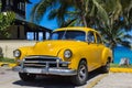 Yellwow american Oldtimer parked under palms near the beach in Varadero Cuba - Serie Kuba 2016 Reportage Royalty Free Stock Photo