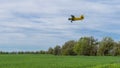 Yelow crop duster airplane flies over the farm field Royalty Free Stock Photo