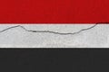 Yemen flag on concrete wall with crack