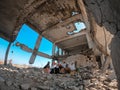 Yemeni children sit on the rubble of their anchorage, destroyed by the war