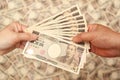 YEN - Japanese money: Hands holding paying / receiving 100,000 yen banknote. Royalty Free Stock Photo