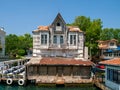 Yenikoy, Istanbul / Turkey - Abandoned old wooden mansion at Bosporus coast and restaurant yard beside it