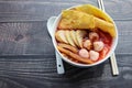 Yentafo noodles, red sauce, fish ball with spoon and chopsticks in white bowl, Thai delicious food isolated on wooden wallpaper Royalty Free Stock Photo