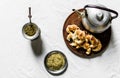 Yerba mate tea, croissants on a wooden board, and kettle on white background