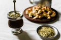 Yerba mate tea, croissants on a wooden board, and kettle on white background