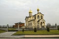 Church of the Life-giving cross of the Lord behind the decorative wrought-iron fence against the cloudy sky, in Yerevan on Admiral