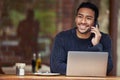 Yes, coming to the cafe was definitely a good idea. a man talking on his cellphone and using his laptop while sitting in Royalty Free Stock Photo