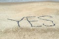 Yes concept word written on sand beach with stones Royalty Free Stock Photo