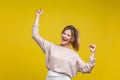 Yes I did it! Portrait of excited beautiful woman with fair hair in casual beige blouse, isolated on yellow background Royalty Free Stock Photo