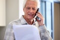 Yes I have a few stipulations I need included. a mature man reading paperwork while making a call. Royalty Free Stock Photo