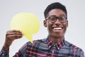 Yes, Im everything they say I am and more. Portrait of a handsome young man holding a speech bubble against a grey. Royalty Free Stock Photo