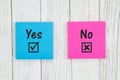 Yes and No on two sticky notes on weathered whitewash textured wood