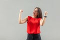 Yes! Portrait of happy beautiful brunette young woman in red shirt standing and celebrating her victory with happiness and Royalty Free Stock Photo