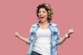 Yes. Portrait of happy cheering young woman with curly hairstyle in casual blue shirt standing with raised arms, screaming and Royalty Free Stock Photo