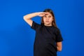 Yes sir. Portrait of responsible obedient little girl with braid in denim overalls saluting and looking at camera with Royalty Free Stock Photo