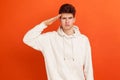 Yes sir! Young patriotic man in casual sweatshirt with hood holding hand near head, saluting, honor and glory, militarisation