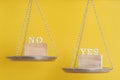 Yes vs No. Choice concept. Balance scales on yellow background. Close up