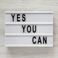 `Yes you can` words on a light box over white wooden surface, top view. Overhead, from above. Flat lay. Close-up Royalty Free Stock Photo