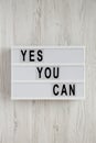 `Yes you can` words on a lightbox over white wooden background, top view. Overhead, from above. Flat lay. Close-up Royalty Free Stock Photo
