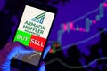 Company logo Armada Hoffler Properties, Inc . AHH on smartphone screen, hand of trader holding mobile phone showing BUY or SELL